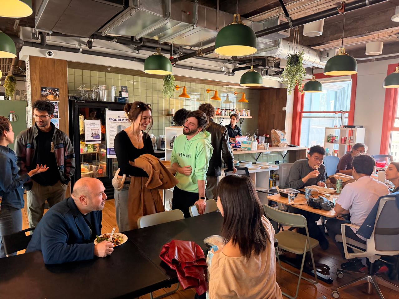 Casual social gathering in the coworking kitchen with people chatting
